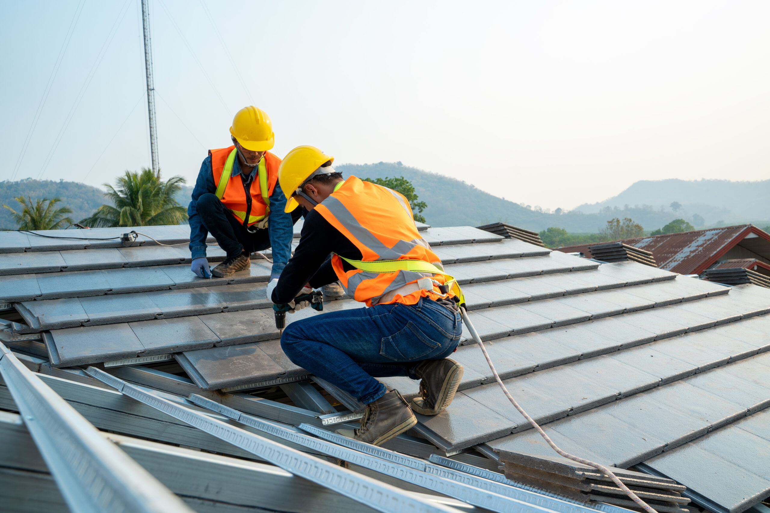 Roofing technician installing ceramic roof on top of the new roof at construction site.